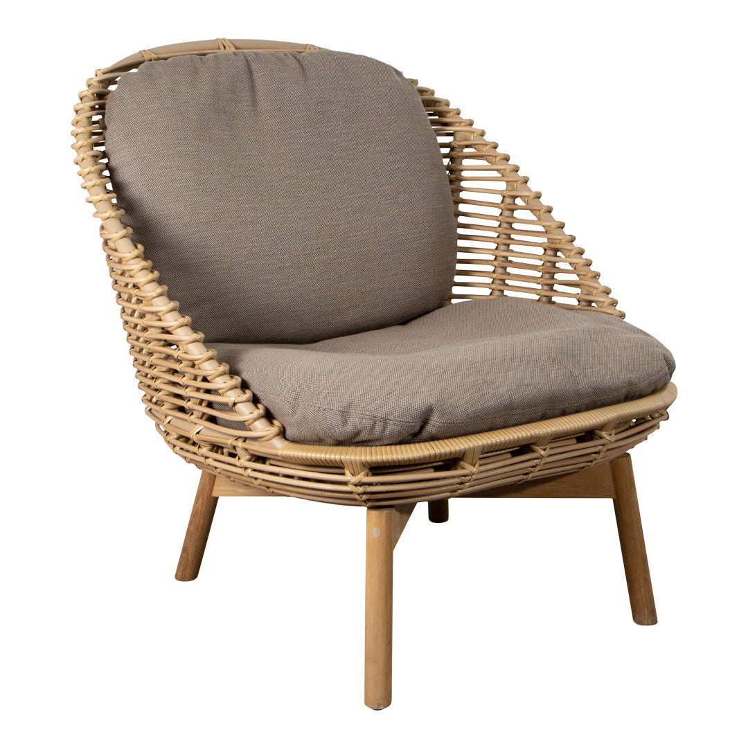 Natural rattan chair with a beige cushion and smooth, curved design. Perfect for modern and cozy interiors.