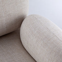 Light beige textured upholstery with a subtle linen pattern, featuring smooth, rounded armrests.