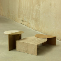 Set of three modern coffee tables in beige and natural wood tones, featuring smooth curves and minimalist design.