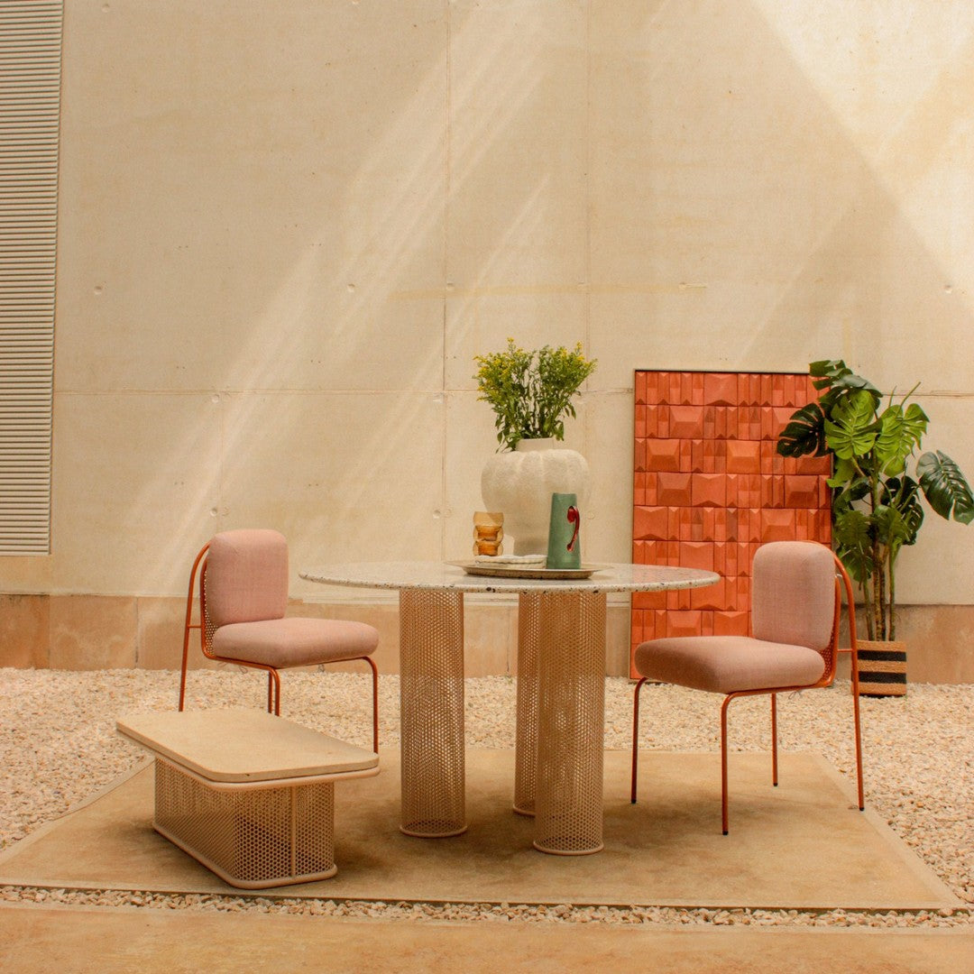 Modern dining set featuring pastel pink chairs, a marble table, and warm earthy tones. Cozy and stylish decor.