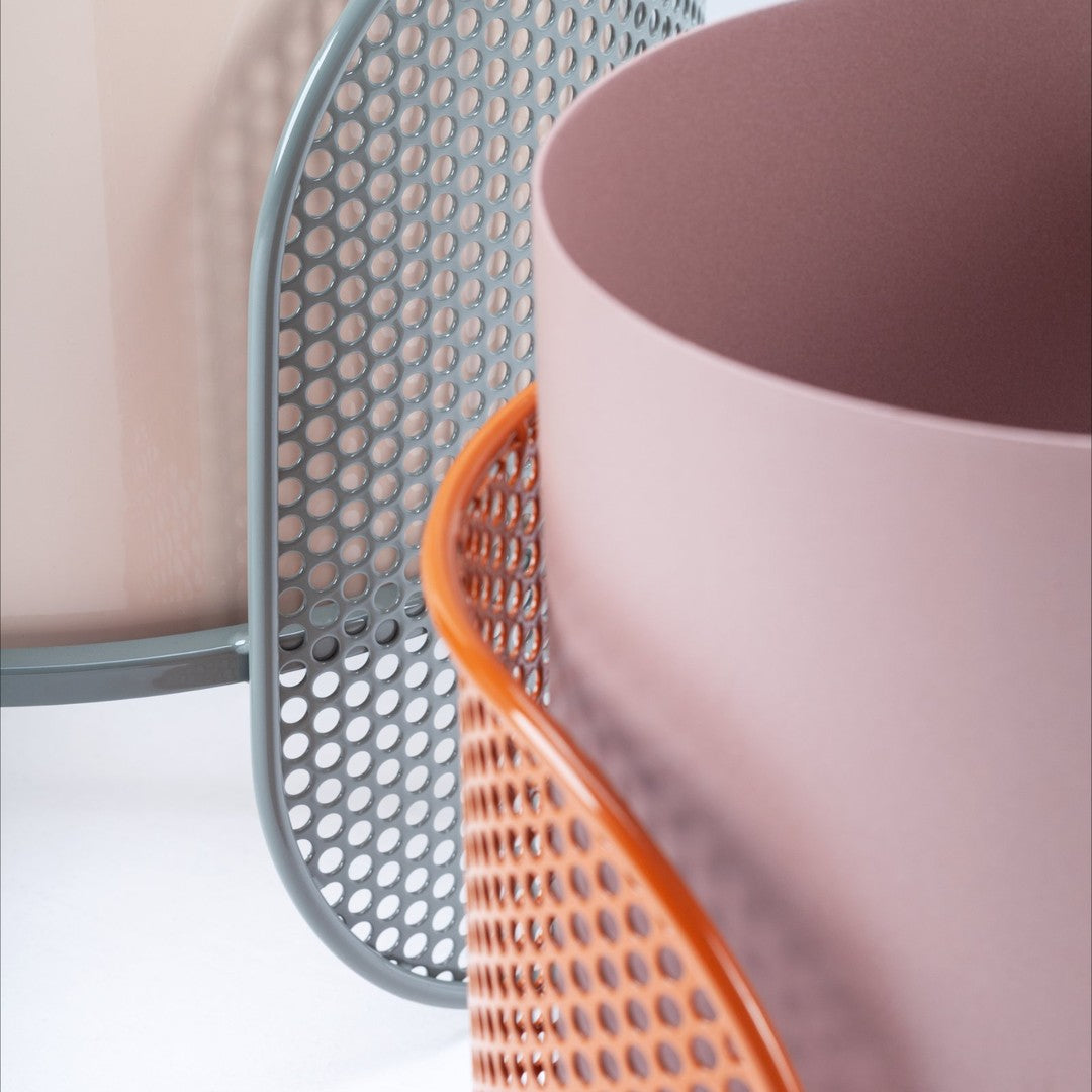 Light pink and gray geometric containers with a vibrant orange mesh accent, showcasing modern patterns.