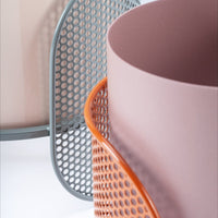 Light pink and gray geometric containers with a vibrant orange mesh accent, showcasing modern patterns.
