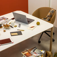 Minimalist white desk with beige chair, orange accent wall, and stylish plaid pattern on chair. Perfect for modern office decor.