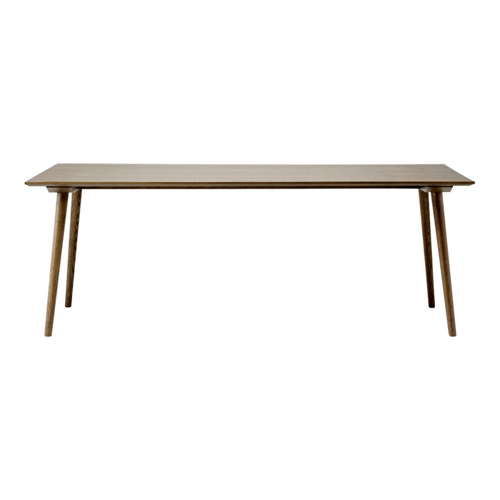 Light brown rectangular table with smooth surface and tapered wooden legs, showcasing a minimalist design.
