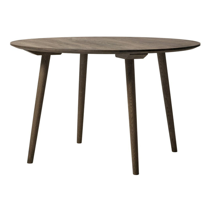 Round wooden table in a rich, dark brown finish with sleek, tapered legs. Textured surface adds a modern touch.
