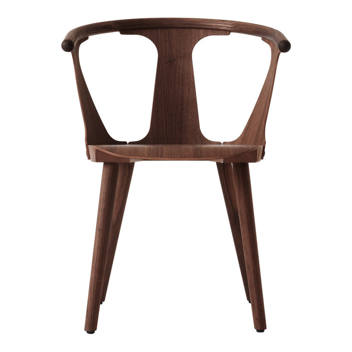 Modern walnut chair with a smooth finish and unique curved backrest, showcasing elegant wood grain patterns.