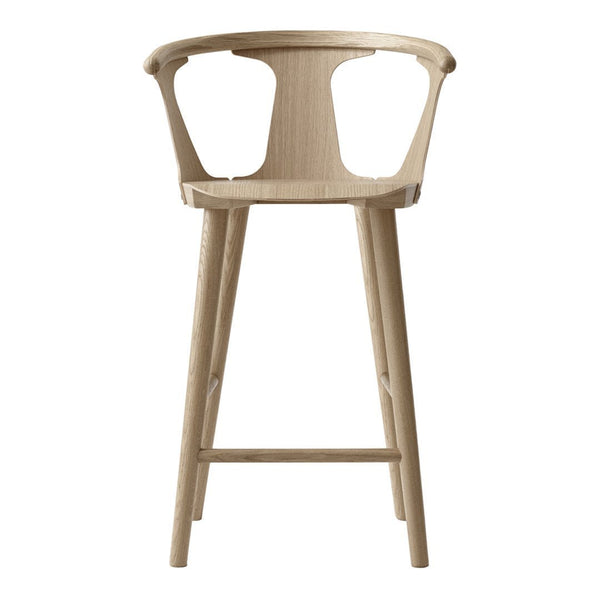 Light wood bar stool featuring a sleek, minimalist design with a natural finish and curved back.