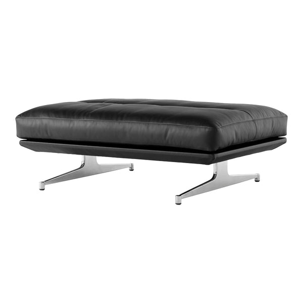 Black leather ottoman with a sleek, minimalist design, featuring a tufted pattern and modern chrome legs.