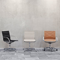 Stylish office chairs in black with polka dots, cream smooth finish, and brown textured leather, set against a gray backdrop.