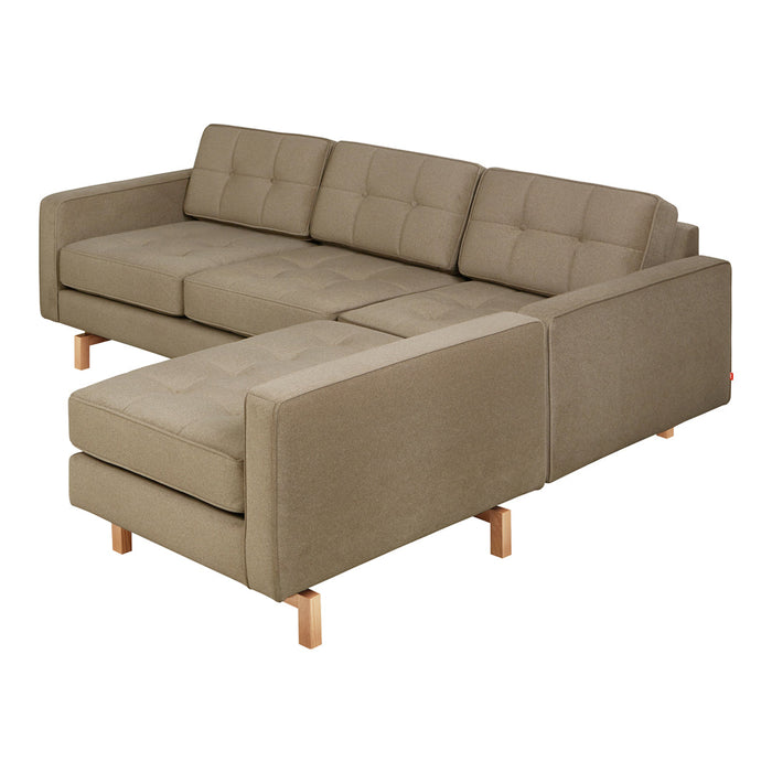 Beige sectional sofa with tufted cushions and light wooden legs, featuring a minimalist design and textured fabric.