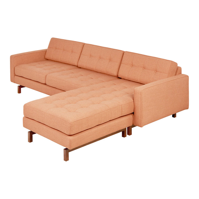 Peach-colored sectional sofa with tufted cushions and wooden legs, showcasing a modern minimalist design.