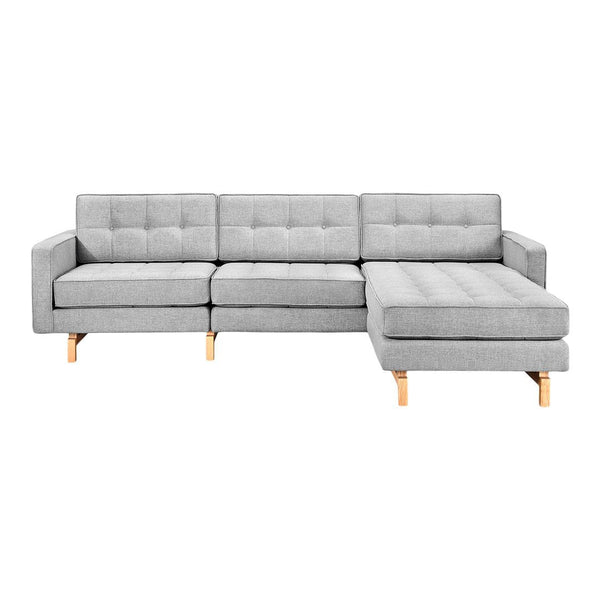 Light gray tufted sectional sofa with wooden legs, featuring a modern and minimalist design.