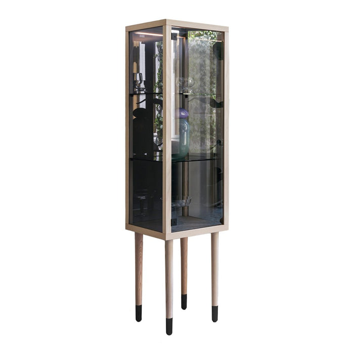 Elegant glass display cabinet featuring a wood frame in light beige with black accents on the legs.