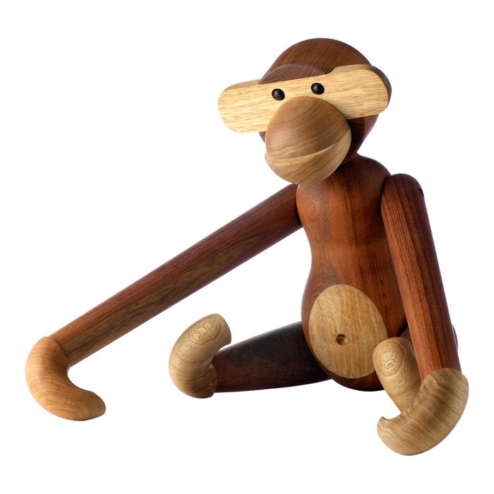 Wooden monkey figurine in brown and beige tones with smooth, rounded shapes and playful design.