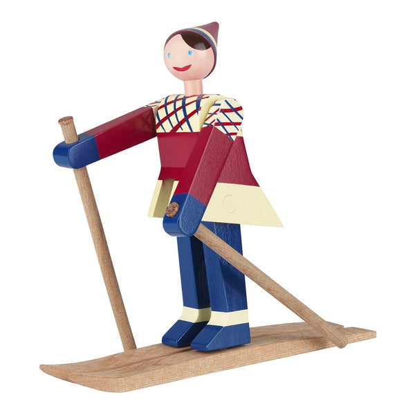 Colorful wooden figure in red, blue, and yellow with a diamond-patterned shirt, standing on a ski.