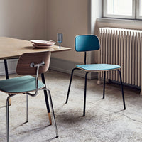 Aqua blue chair with a sleek black frame, positioned beside a light wood table with neutral tones.