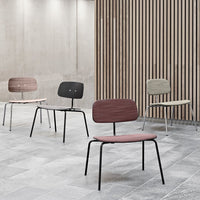 Set of four minimalist chairs in burgundy, green, light wood, and black, with simple, clean lines against a modern backdrop.