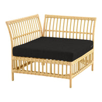 Natural rattan lounge chair in light tan with a solid black cushion, featuring a minimalist vertical slat pattern.