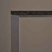 Gray metal frame with a rugged dark stone top against a neutral background. Perfect for modern decor.