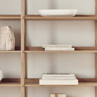 Light wood shelving with neutral decor, featuring soft whites and natural textures for a minimalist style.