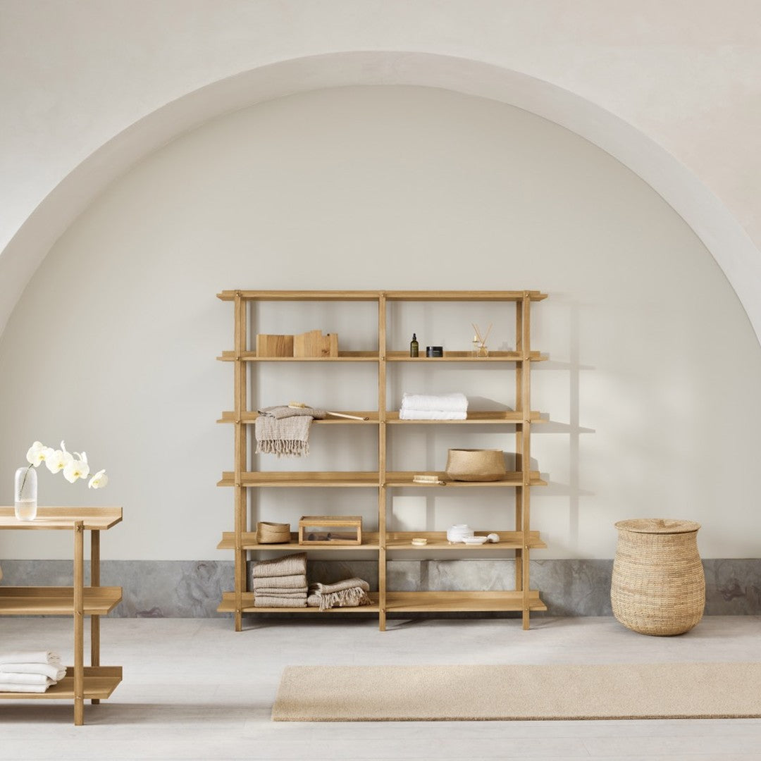Natural wood shelving unit with a light beige wall and neutral decor accents, creating a minimalist aesthetic.