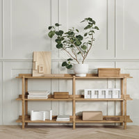 Natural wood finish shelving with light and neutral accents, featuring greenery and clean lines for a modern, serene look.