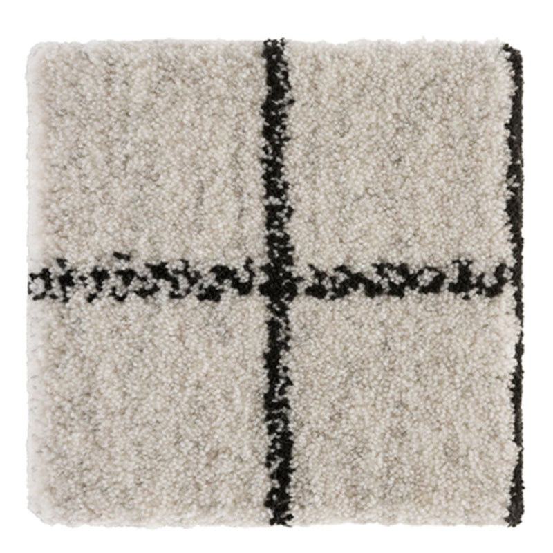 Cream shag rug with a bold black grid pattern, adding texture and modern style to any space.