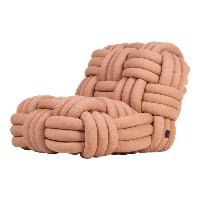 Pastel peach velvet chair with a unique knotted pattern, adding a modern touch to any decor.