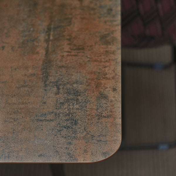 Textured tabletop in warm orange and brown hues, featuring subtle dark speckles and an aged, distressed pattern.