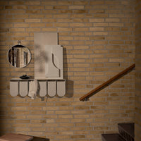 Light beige wall shelf with rounded edges, complemented by a round mirror and subtle textures against a brick backdrop.