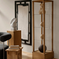 Modern display case featuring wood and glass with neutral color tones and smooth, minimalist shapes.