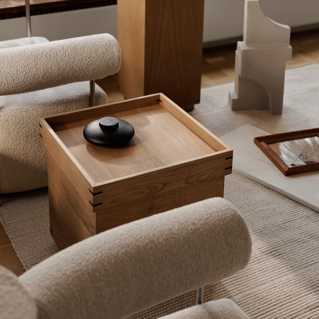 "Natural wood grain with sleek black accents; soft beige and woven textures create a warm, inviting atmosphere."