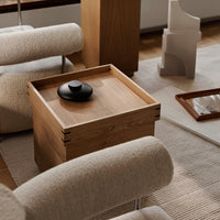 "Natural wood grain with sleek black accents; soft beige and woven textures create a warm, inviting atmosphere."