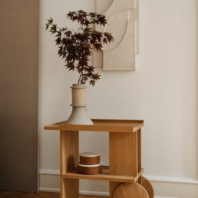 Wooden cart with a natural finish, featuring warm tones and minimalist design, adorned with earthy plants and textures.