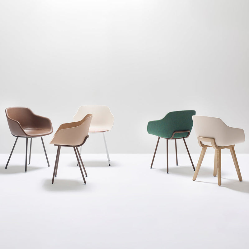 Five modern chairs in beige, brown, green, and cream, showcasing sleek lines and minimalist design.