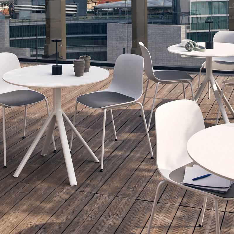 Modern outdoor seating featuring gray and white chairs around a sleek white table set on a wooden deck.