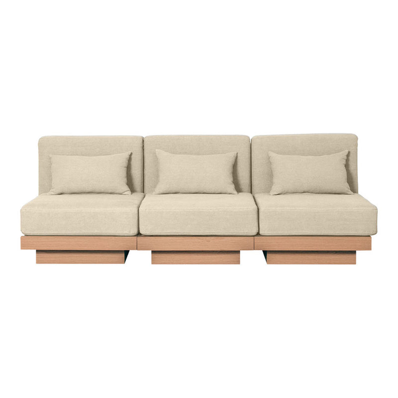 Beige modular sofa with smooth surface, minimalist design, and matching throw pillows on a wooden base.