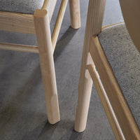 Natural wood tones with a light gray fabric pattern, showcasing a minimalist design in a modern setting.