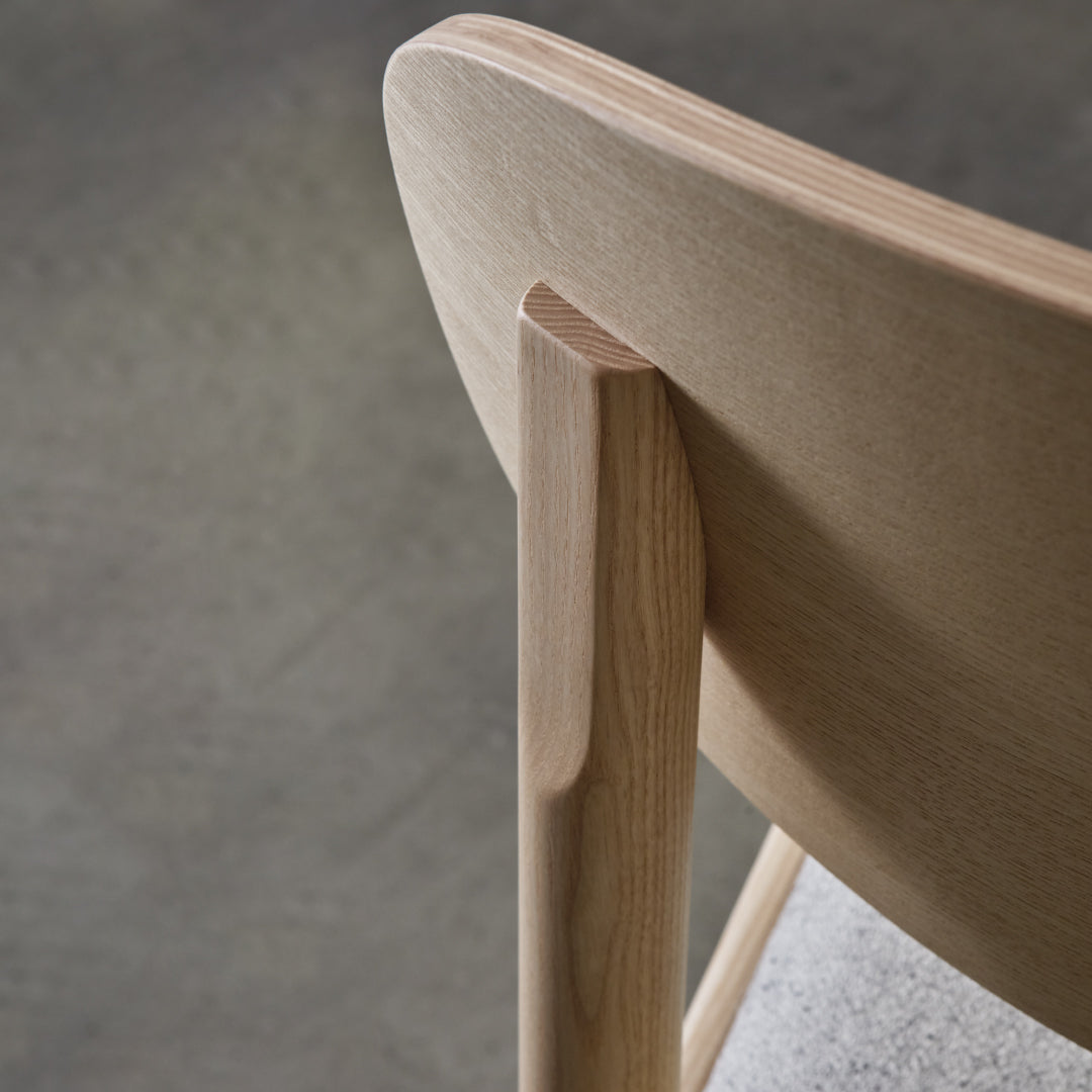Light wood textures with smooth, natural grain and a soft gray upholstered seat pattern.
