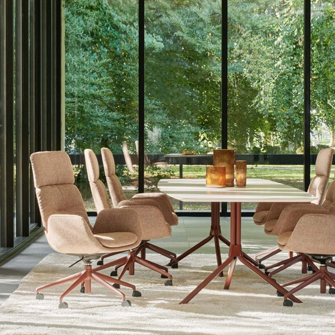 "Brown textured chairs with a modern white table, set against a backdrop of greenery and natural light."