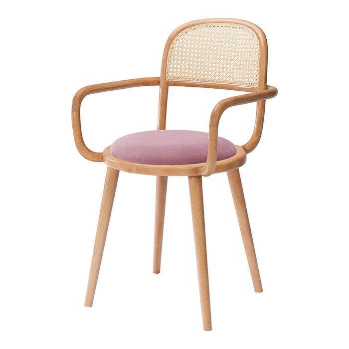Natural wood chair with cane back and soft pink velvet seat, featuring a minimalist design and smooth, rounded edges.