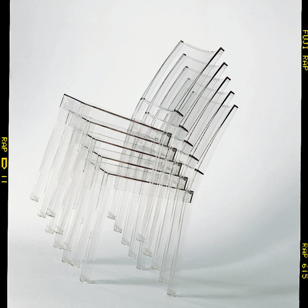 Stack of clear, transparent chairs with subtle linear patterns against a minimalist white background.