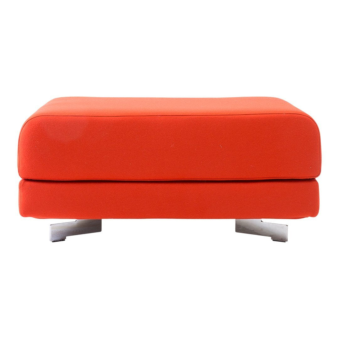 Bright orange upholstered ottoman with a sleek design and silver legs, perfect for modern decor.