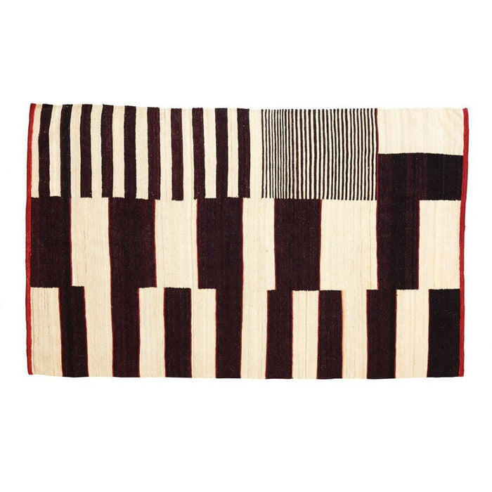 Black and cream geometric pattern rug with striped and block designs, accented by a rich red border. Perfect for modern decor.