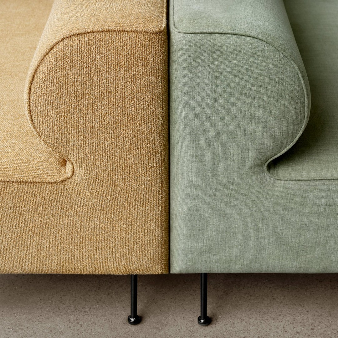 Two-tone sofa featuring a golden yellow side and a soft green side with smooth, textured upholstery.