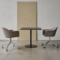 Gray upholstered chairs with sleek black table against a neutral backdrop of beige and light gray tones.