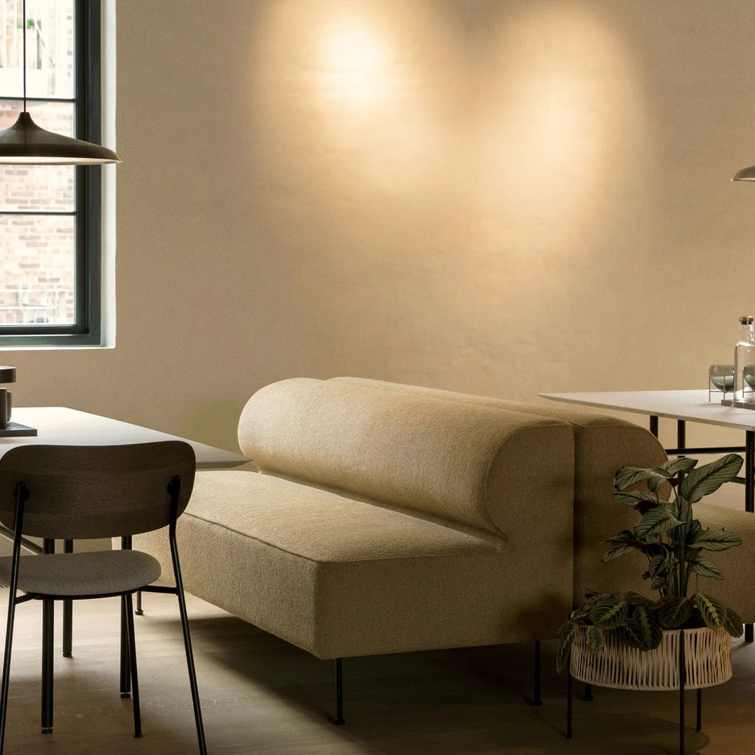 Beige curved sofa with a textured fabric, complemented by neutral tones in the surrounding decor.
