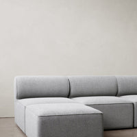 Gray textured sofa with a modern pattern, featuring soft hues and sleek lines, perfect for contemporary decor.