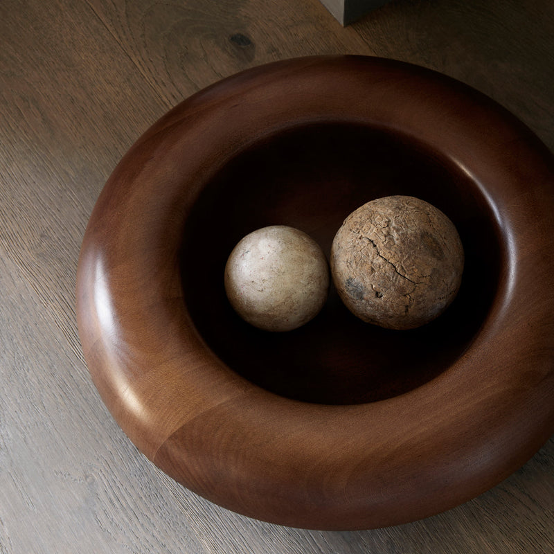 Brown wooden bowl with smooth finish, featuring light beige and textured brown decorative spheres inside.