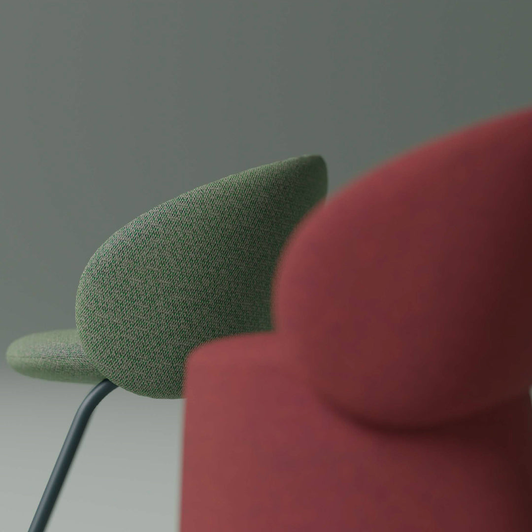 "Green patterned chair and red solid chair against a neutral backdrop, showcasing modern design elements."